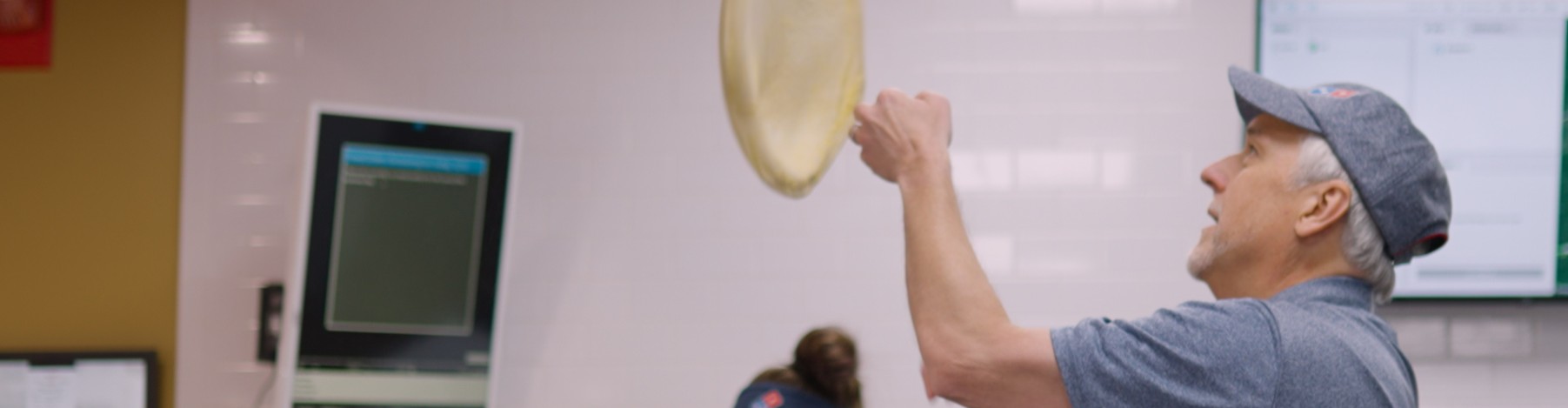 Dominos employee tossing pizza