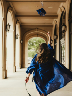 Girl throwing graduate cap in air