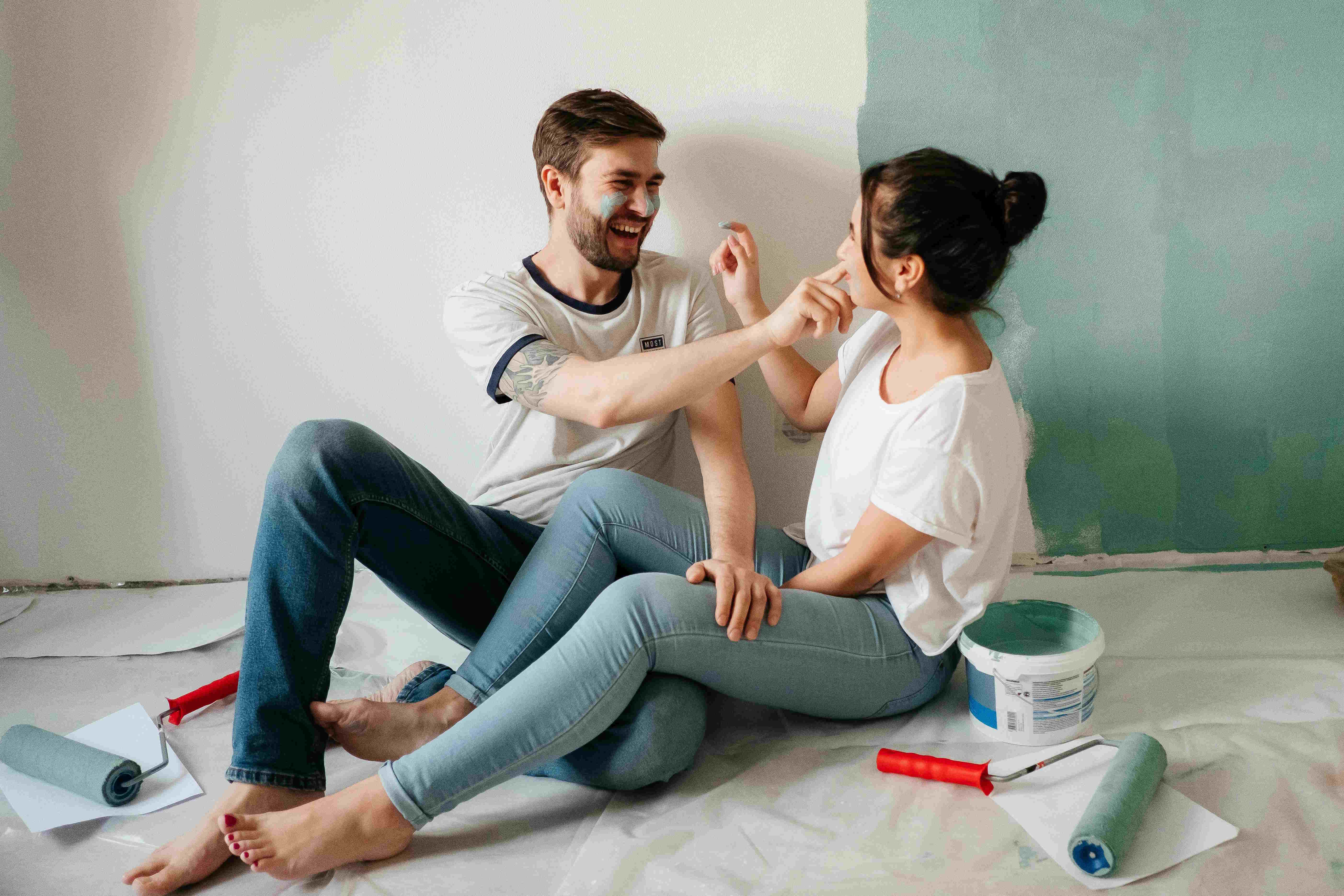 Couple painting their home and laughing