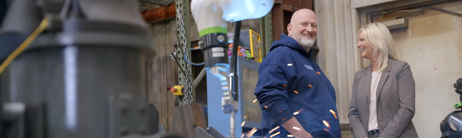 Customer and lending officer standing in welding shop