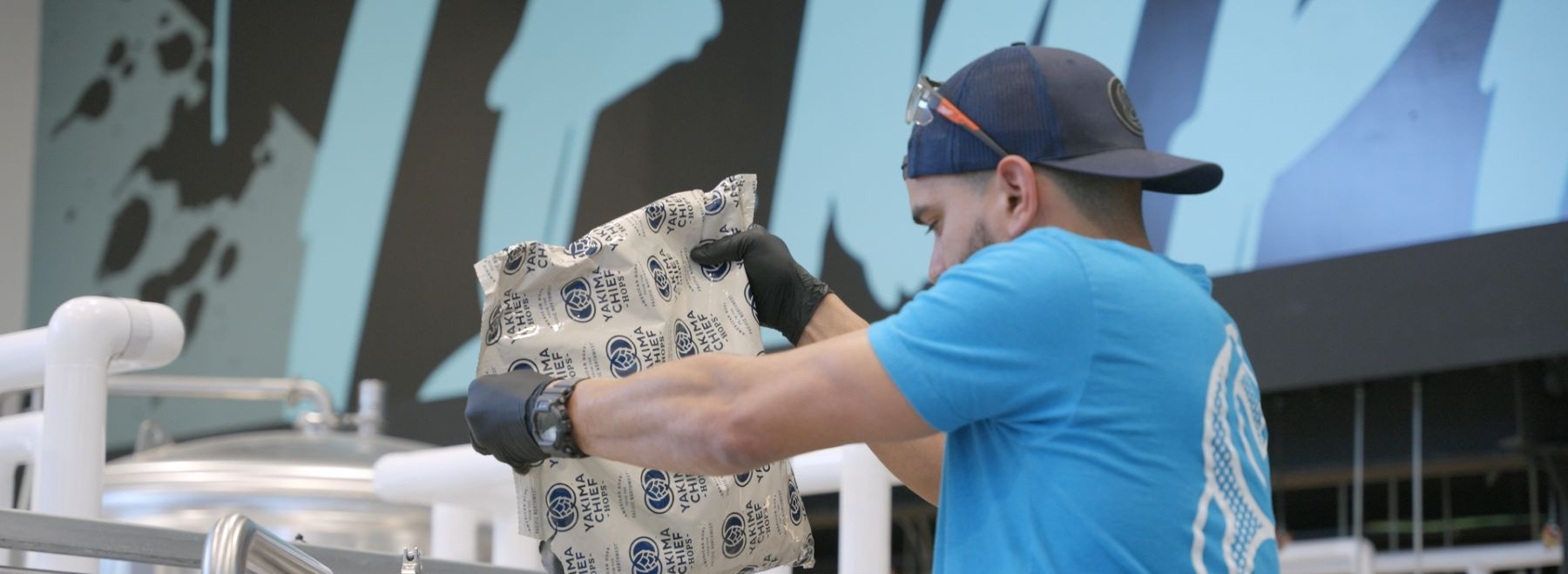 Man pouring hops into machine