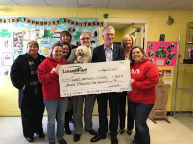 Lowell Five handing an oversized check to Staff of Humane Society